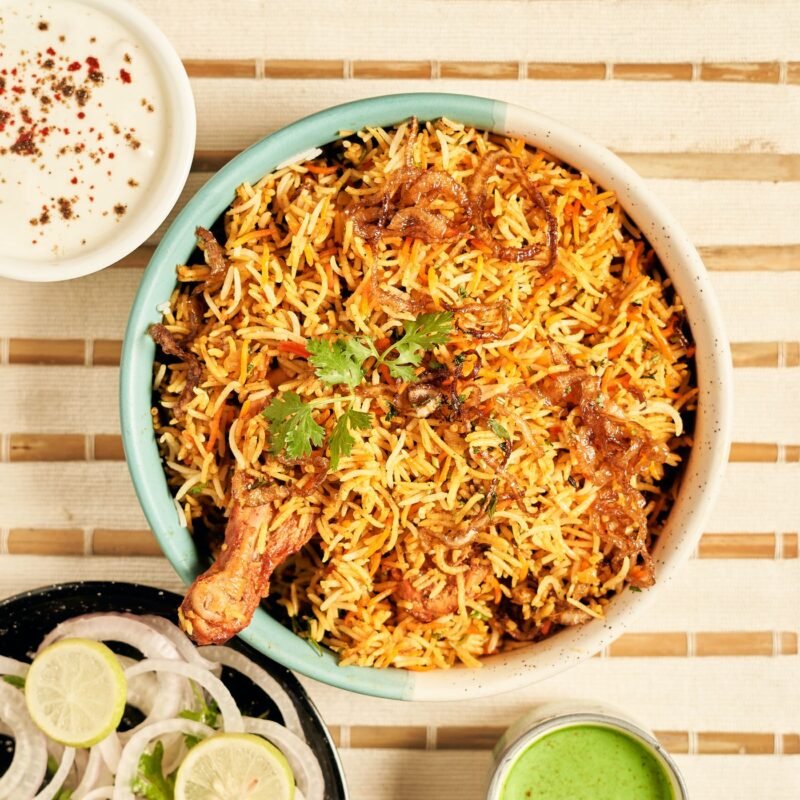 Chicken biryani served with raita and onion salad