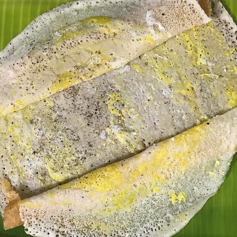 Dosa topped with a layer of spiced egg