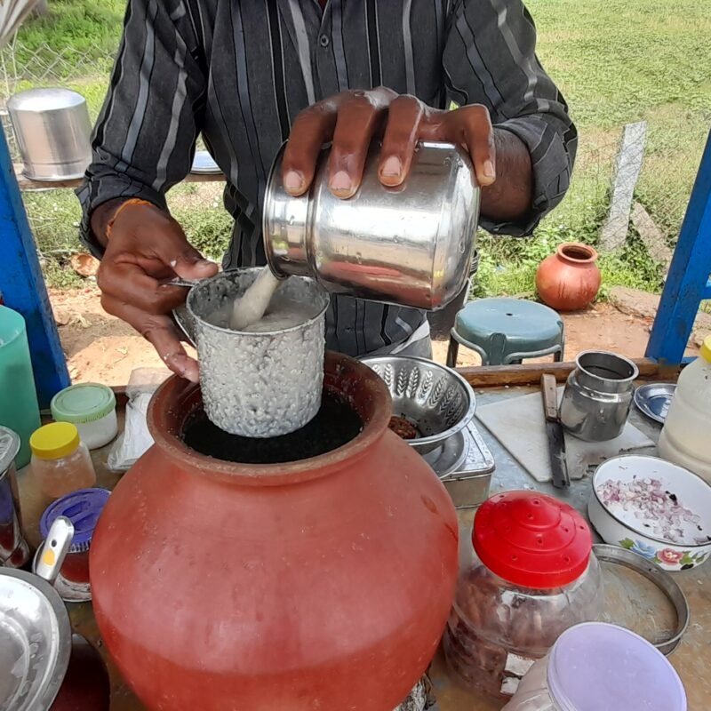 Millet porridge (koozh) being served from a clay pot