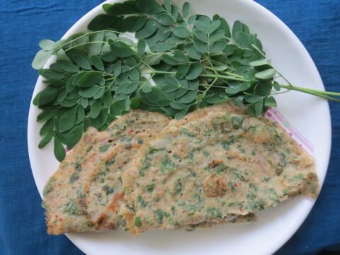 Savoury greens adai served with fresh moringa leaves