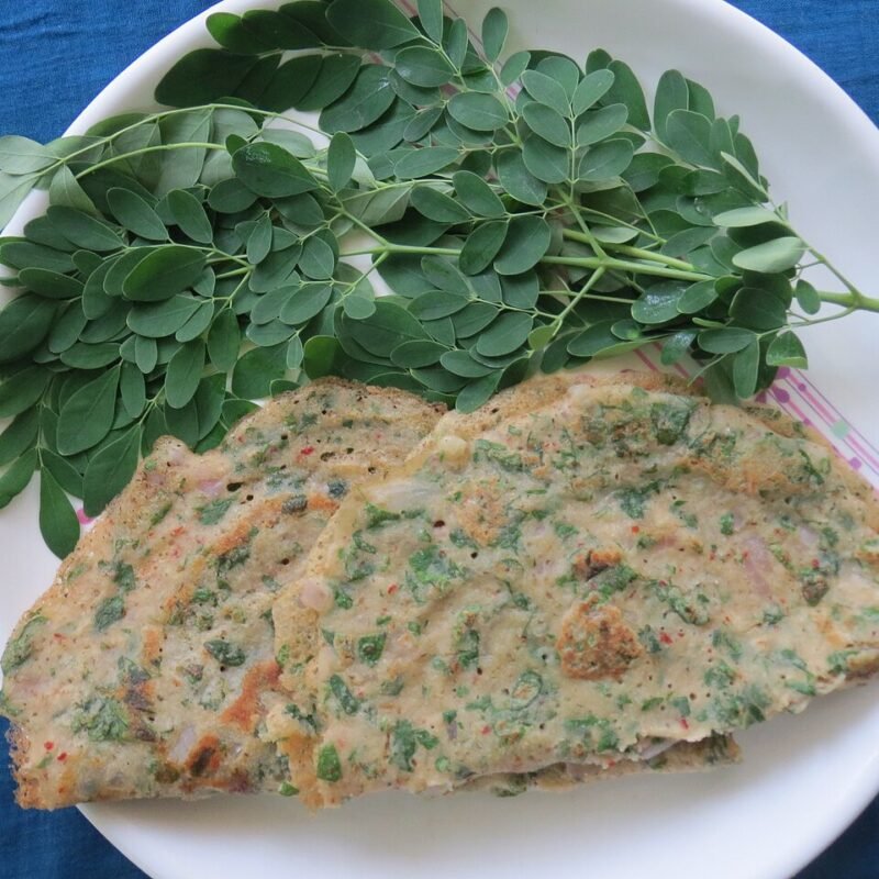Savoury greens adai served with fresh moringa leaves