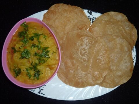 Puffed golden poori served with potato masala